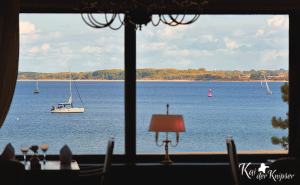 Blick aus einem Restaurantfenster des Maritims Travemünde auf die Lübecker Bucht / Ostsee mit Segelbooten.